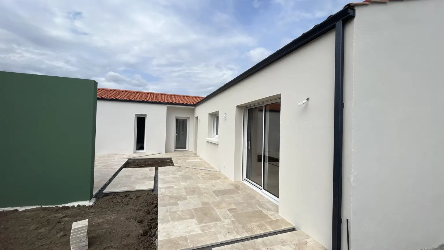 Façade de l'extension de plain-pied et terrasse en pierre — Le Caillou blanc, Vendée