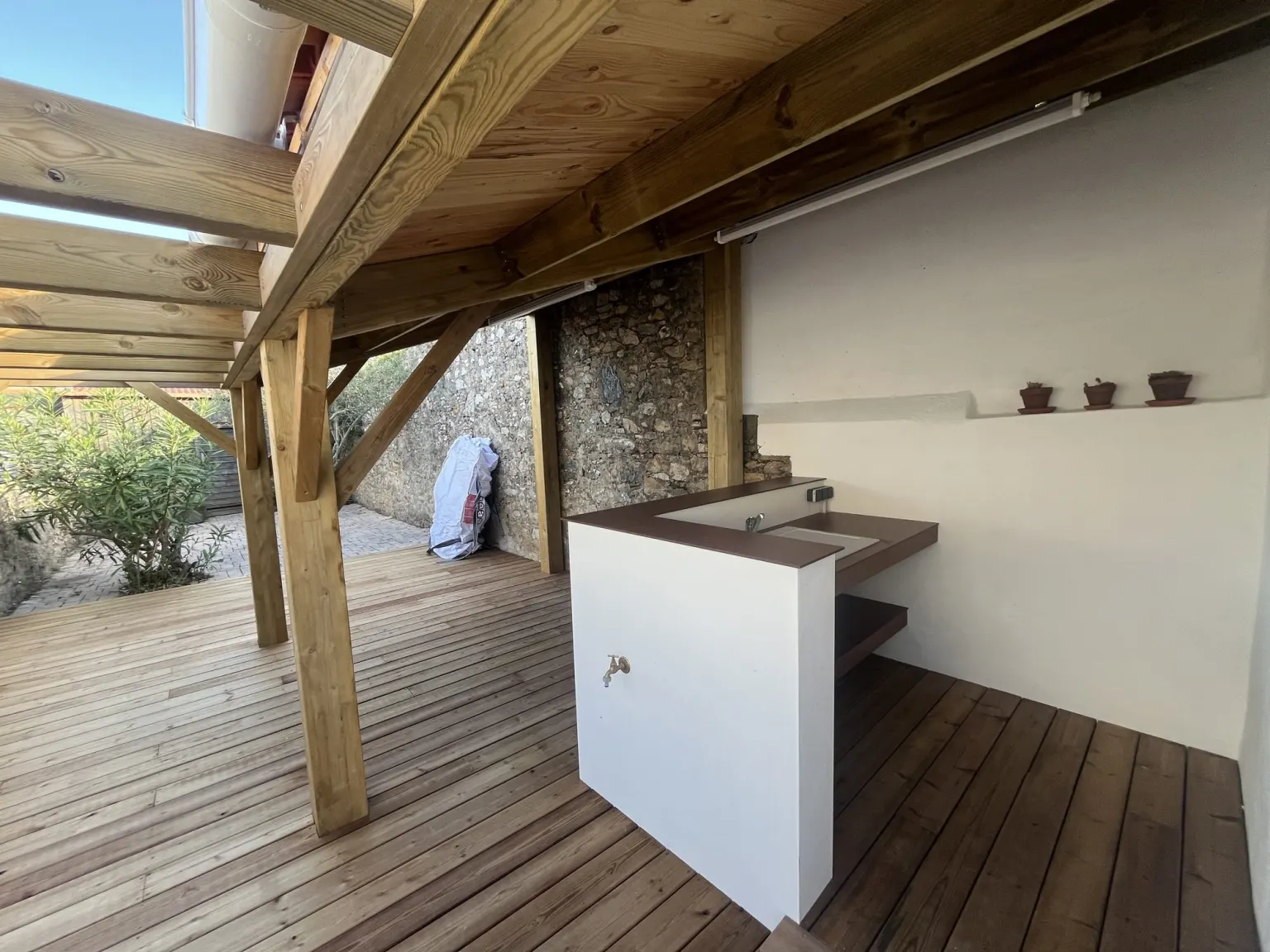Cuisine d'été sous pergola sur la terrasse en bois — maison de vacances à La Chaume