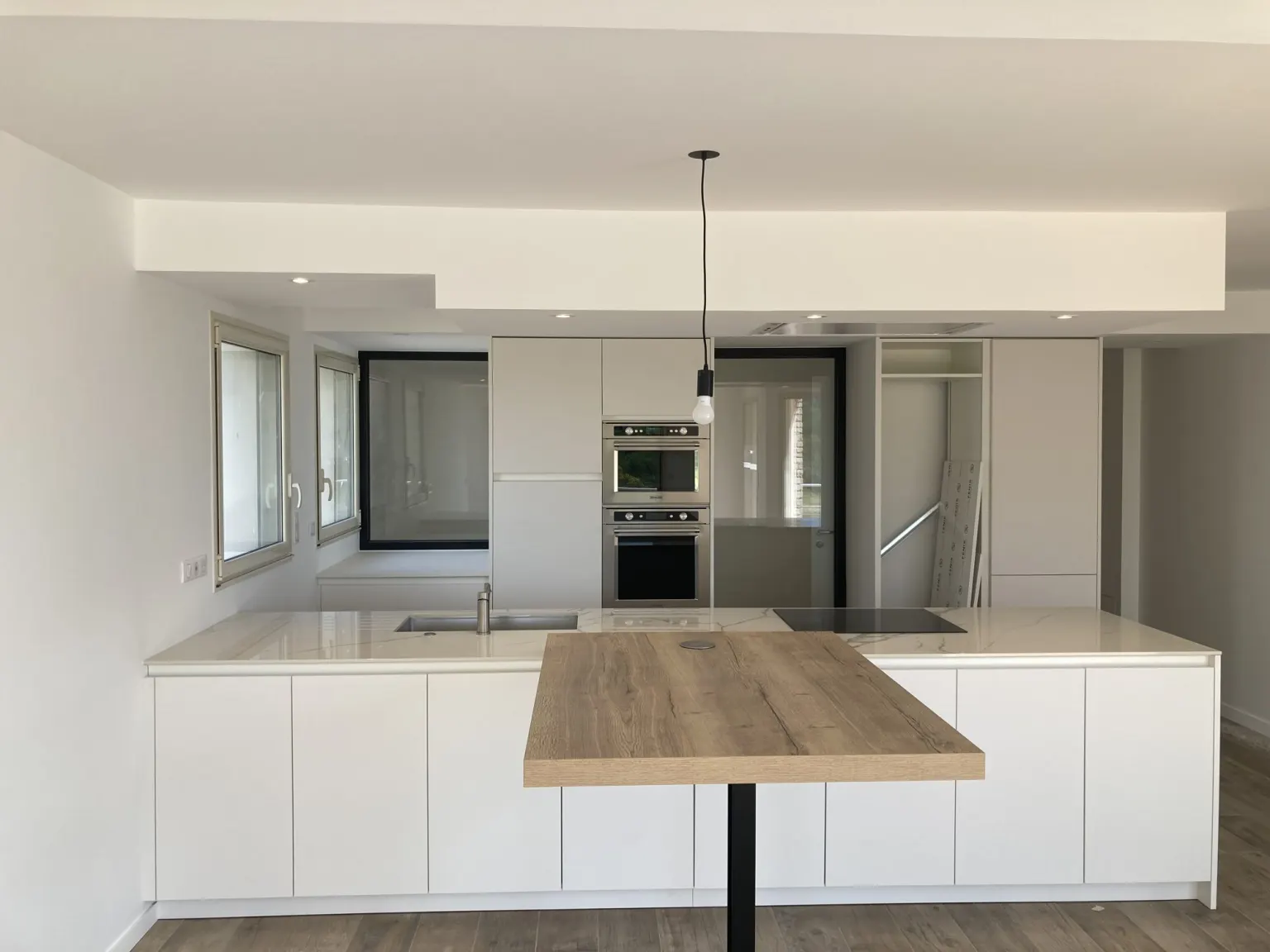 Cuisine blanche avec îlot et plan en bois — villa des années 80 Sur la Corniche