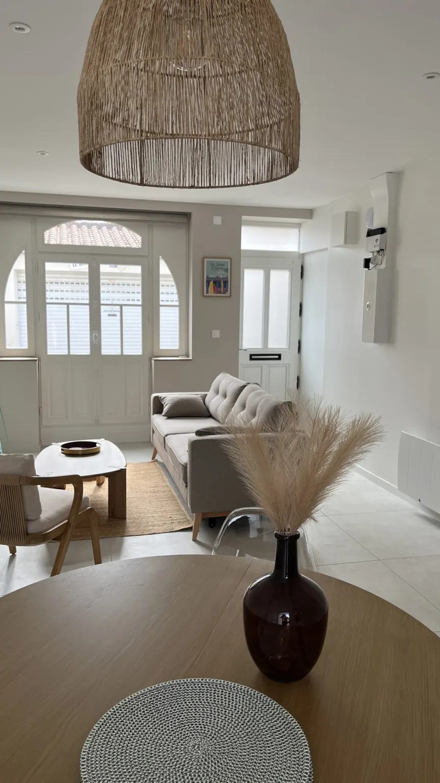 Séjour lumineux avec fenêtre cintrée et sol clair — maison Le Roulis rénovée par Batimium