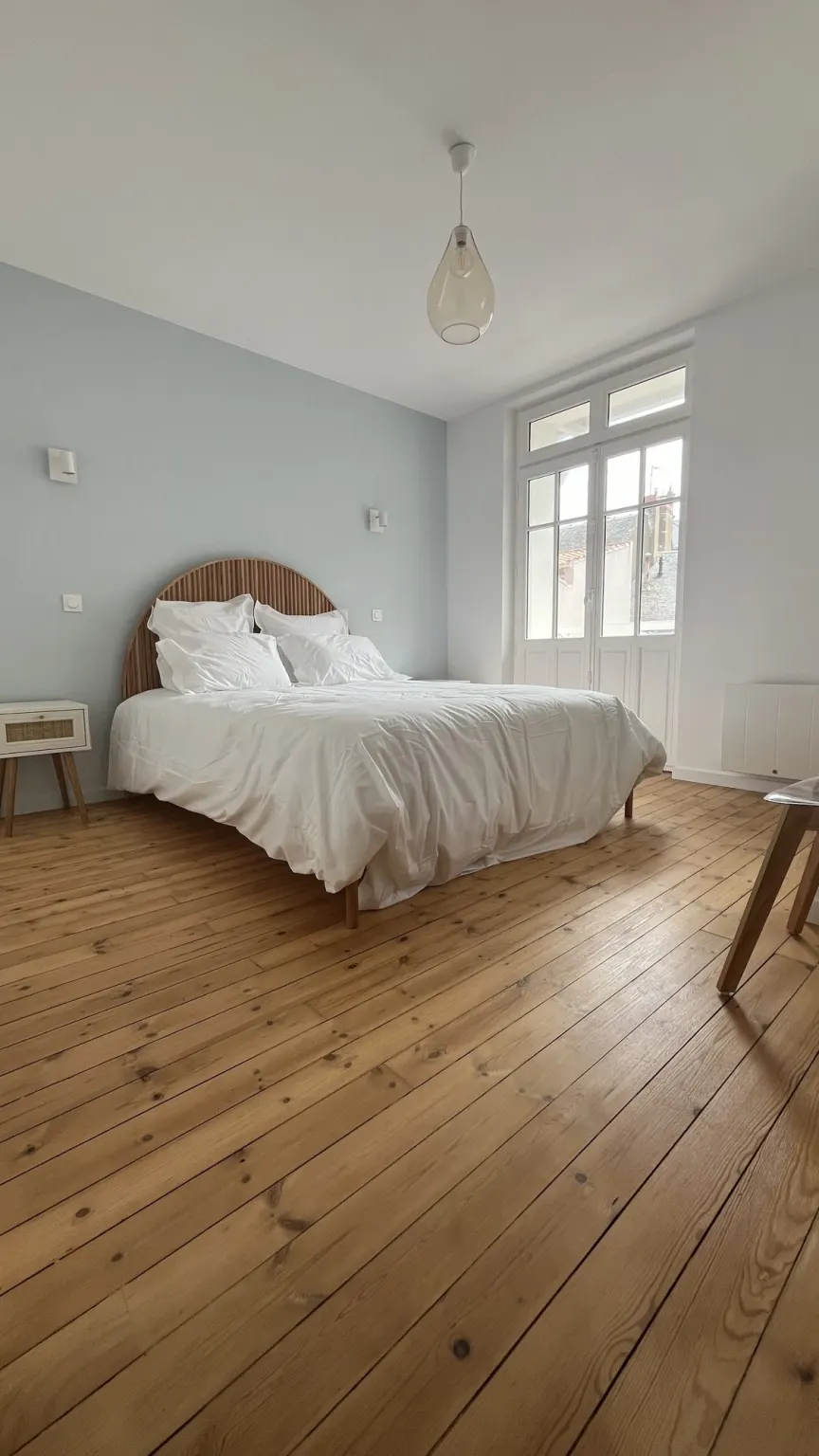 Chambre avec parquet en bois brut et murs vert d'eau — maison Le Roulis rénovée