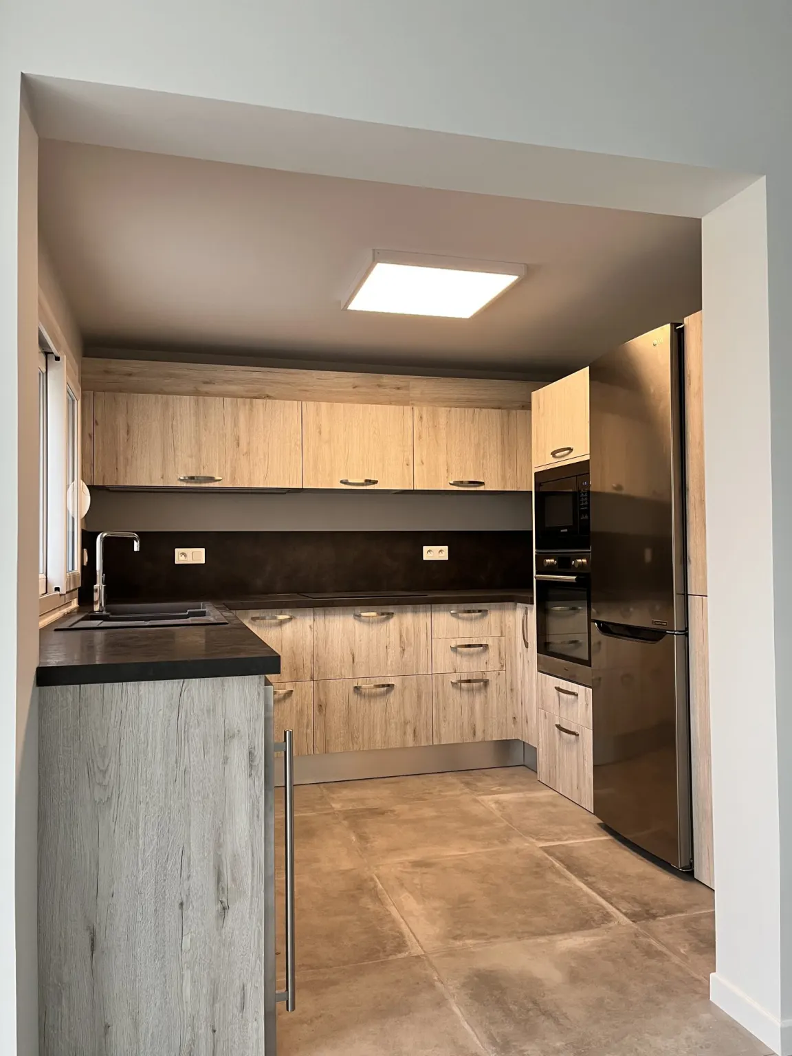 Cuisine en bois clair et plan de travail noir — maison Sur le Vallon rénovée